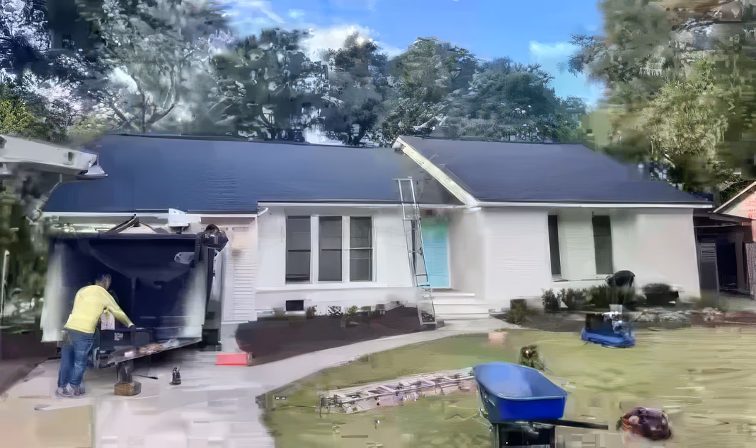 A finished new shingle roof on a white brick house